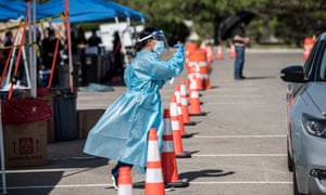 A nurse beckons to people in a car at a newly opened mega drive-thru site at El Paso Community College Valle Verde campus on 21 July 2020 in El Paso, Texas.