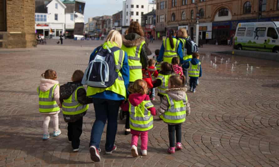 Pre-school children walk around Blackpool with staff.