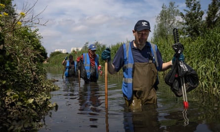 A river cleanup organised by the waterway advocacy group Thames21 in London, removing litter and plants such as Himalayan balsam.