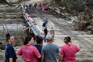 People look on as law enforcement and volunteers continue to search for missing people