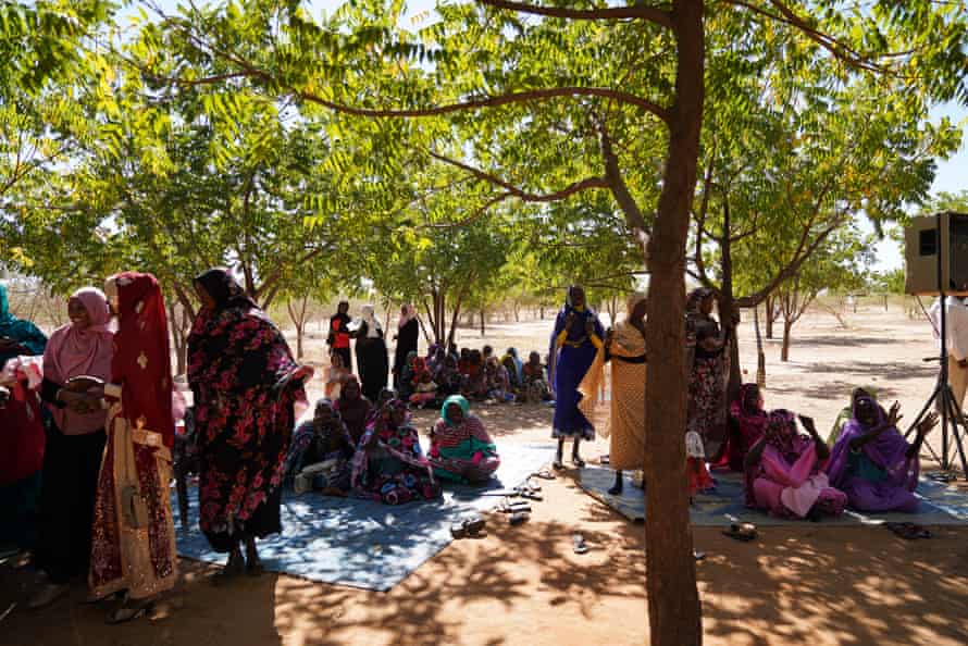 Women under the shade of the trees they planted during the performance of Sasa.