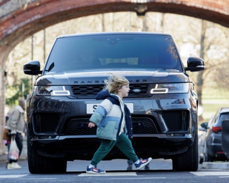 A child closing a road in from of a Range Rover car