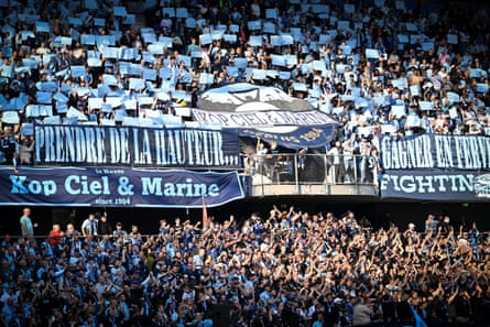 two tiers football stadium with fans holding placards
