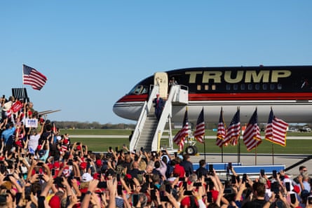 a man exits a plane that has his last name on it in large letters