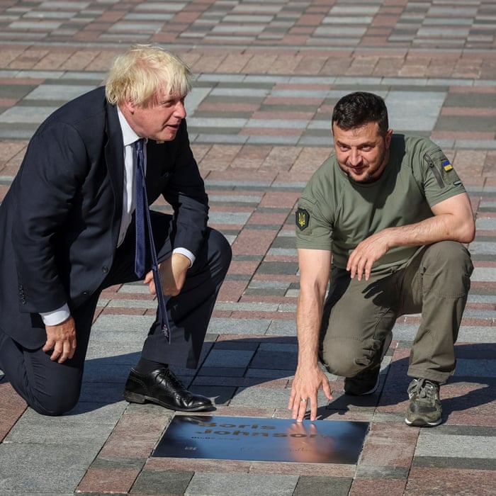 Ukraine’s President Zelenskiy and British Prime Minister Johnson open a plate with his name on the Alley of Bravery in Kyiv.