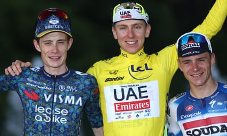 Tadej Pogacar celebrates on the podium, flanked by runner-up Jonas Vingegaard (left) and third-placed Remco Evenepoel.