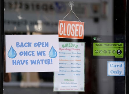 A sign on a restaurant door says ‘back open once we have water!’