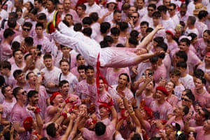 Revellers in white throw a man in the air