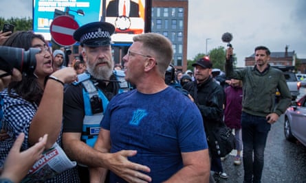 A police officer escorts a man away from anti-racist counter-protesters.