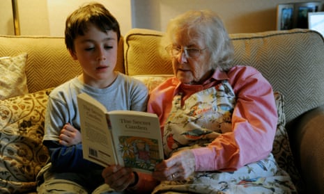 Grandmother listening to grandson read on sofa