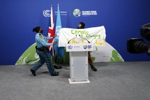 A security officer approaches a protester who has entered the plenary hall at the close of Cop26