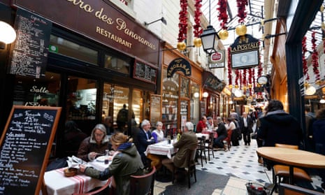 People sit outside bistros for lunch in the Passage des Panoramas, Paris.