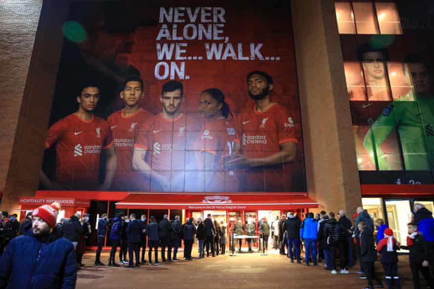 Les fans attendent que leurs passes Covid soient vérifiées par les officiels avant le match de Liverpool contre Newcastle à Anfield.