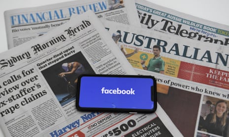 The Facebook logo seen on a phone which is placed on a pile of Australian newspapers