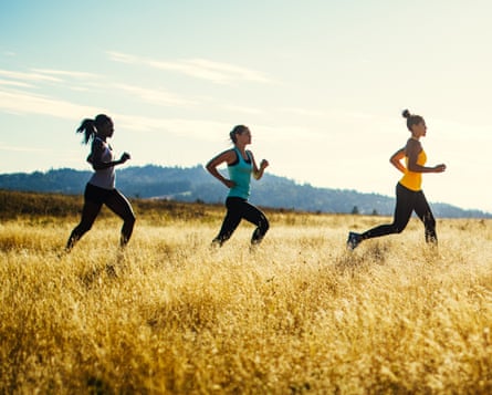 Three women running through a field.