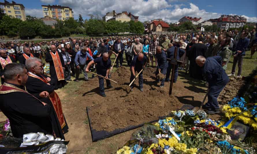 Workers bury the coffin with the body of Artem Dymyd, a Ukrainian service member who was recently killed in a battle against Russian troops, as Russia’s attack on Ukraine continues, during a funeral ceremony in Lviv, Ukraine June 21, 2022.