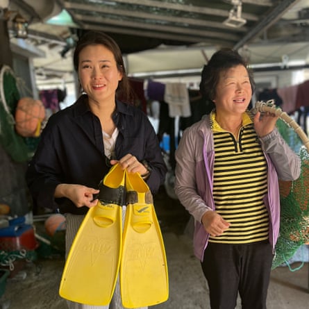A young woman holding yellow flippers next to an older woman