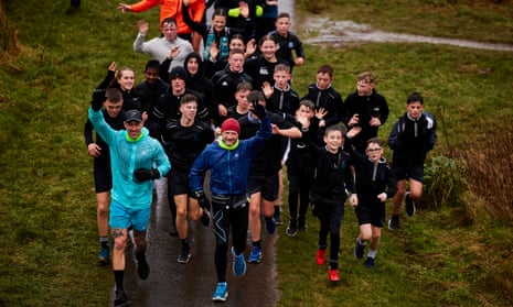 Gary McKee (centre) running on 19 December 2022 accompanied by pupils from Workington Academy, Cumbria.