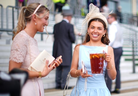 A racegoer holds a jug of Pimm's.