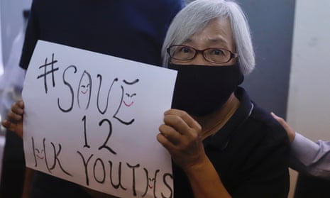 A pro-democracy activist displays a #save12HKyouths poster calling for the release of the youths held since they tried to escape Hong Kong for Taiwan by boat.