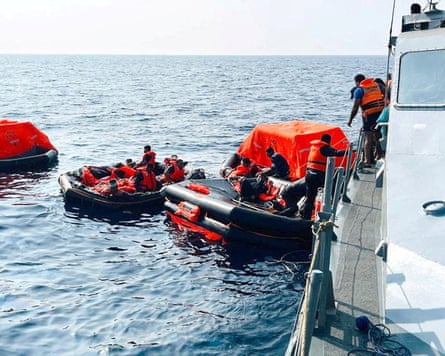 People on life rafts in the Indian Ocean are brought on to another ship