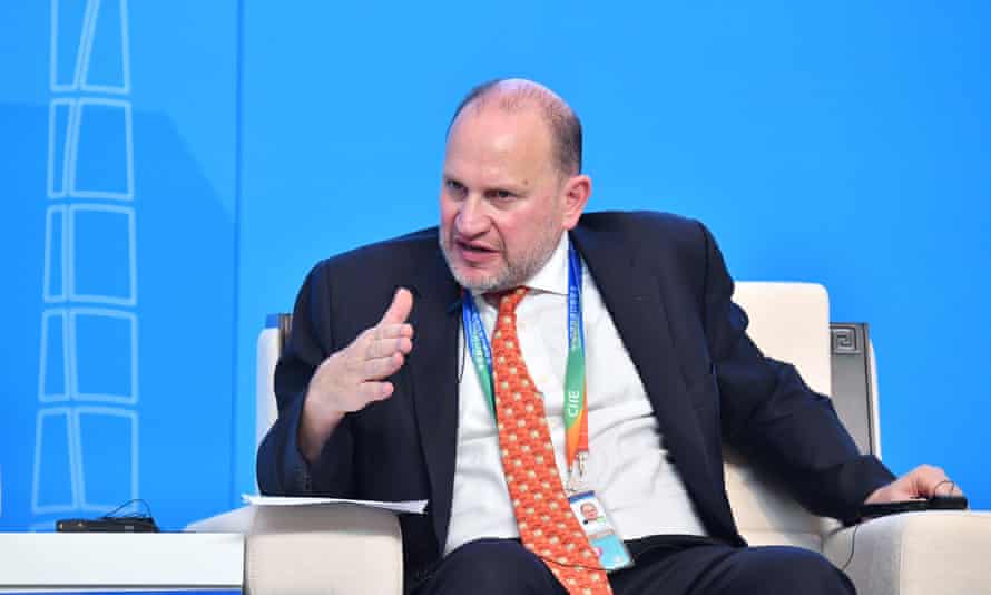 Mark Tucker, seated, gesturing as he speaks on stage during a briefing or presentation