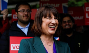 Rachel Reeves smiles in front of a group of people holding Labour party signs