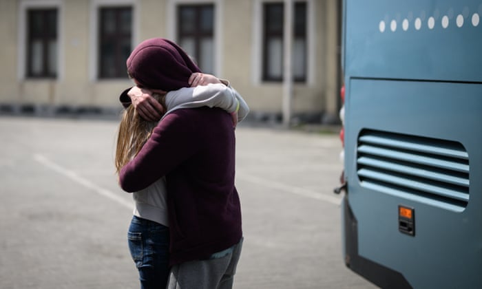 A young couple embrace before a bus leaves for Przemyśl in Poland, carrying refugees from regions of Southern and Eastern Ukraine, including Mairupol, in Lviv, Ukraine.