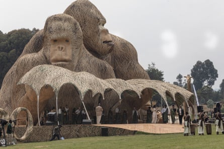 Two huge gorilla statues from the backdrop to a stage. People are