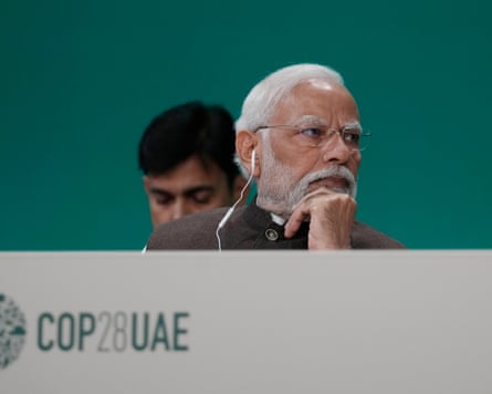 Narendra Modi attending a plenary session at Cop28 with an earphone in his ear