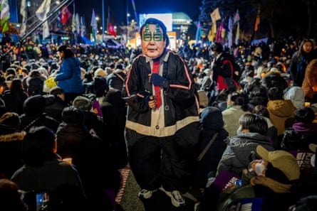 A protester dressed as Yoon, wearing handcuffs