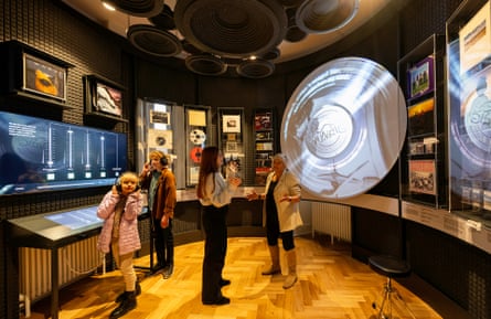 People listen on headphones and explore music memorabilia