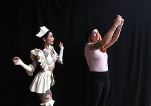 Tattoo enthusiasts pose for photographs during the London Tattoo Convention at Tobacco Dock
