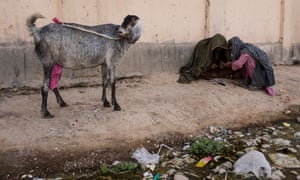 Opium addicts gather to smoke by a wall in a public park in Lashkar Gah.