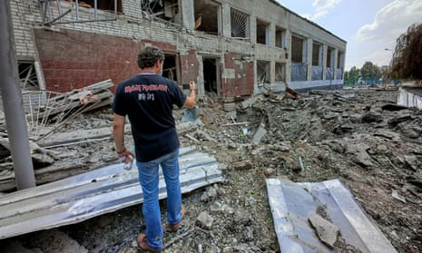 Rescuers clean debris at a school destroyed by rockets in Kharkiv.
