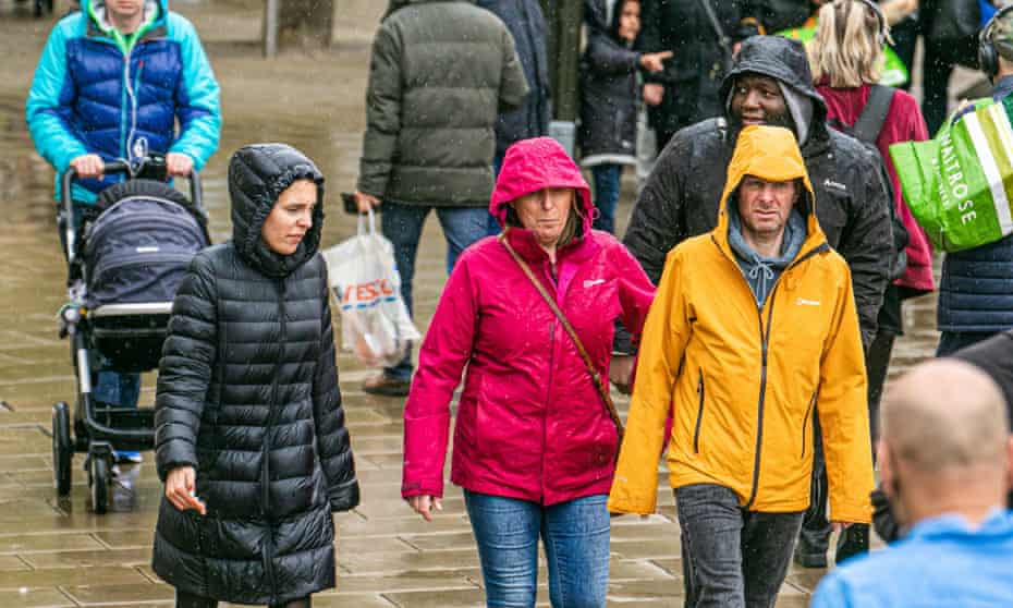 Pedestrians in Wimbledon town centre walk in the rain, 16 May 2021.