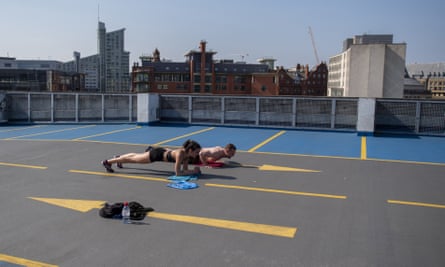 A man and a woman exercise on top of a multistorey car park in Manchester.
