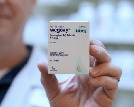 A pharmacist holding a box of Wegovy pills