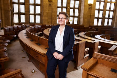 Bev Craig smiling in the otherwise empty Manchester council chamber