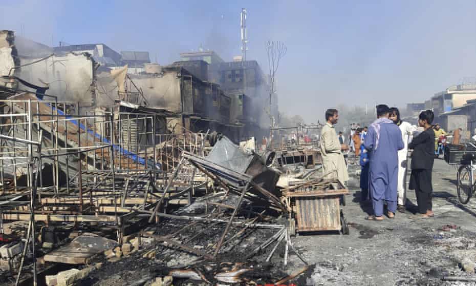 Afghans inspect damaged shops after fighting between the Taliban and Afghan security forces in Kunduz.