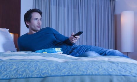 A man on a bed watching TV