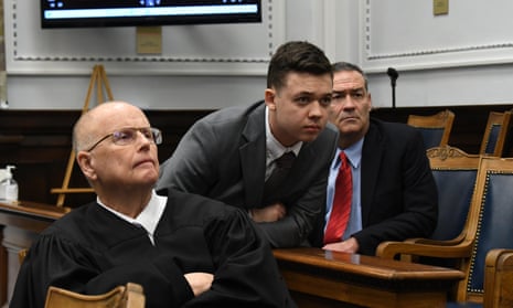 Judge Bruce Schroeder, left, Kyle Rittenhouse, center, and attorneys watch a large video monitor at Rittenhouse’s murder trial in Kenosha, Wisconsin.