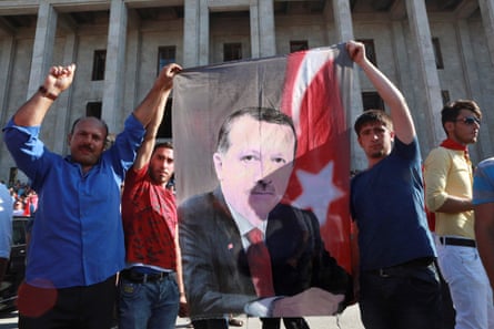 People hold a banner depicting Erdoğan as they gather outside the Turkish parliament.
