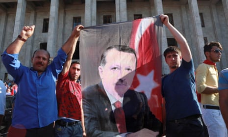 People hold a banner depicting Recep Tayyip Erdoğan as they gather outside the Turkish parliament in Ankara on 16 July.