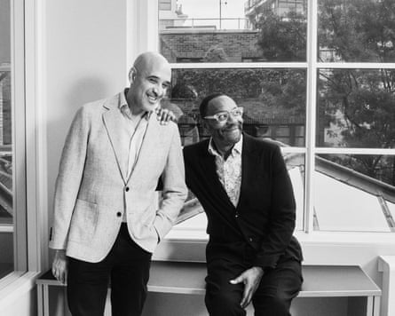 A black and white photograph f two men looking to the right of the camera and smiling