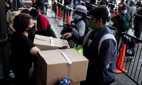 Volunteers help people distributing care packages with food donations from the Food Bank for New York City in Brooklyn.