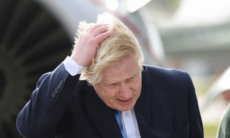 Boris Johnson looking exasperated with one hand on his head