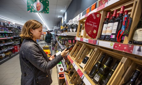 Shopper looking at festive bottles of wine in a supermarket