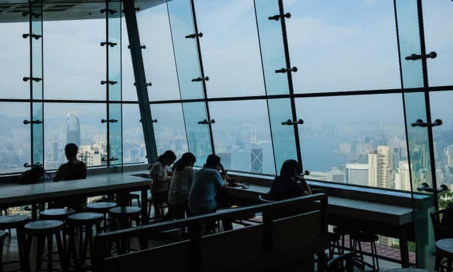 People sit in a Hong Kong cafe with view of harbour