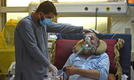 A man comforts a family member suffering from Covid-19 at the intensive care unit of the Muhammed Ali Jinnah hospital in Kabul, which has been forced to close because of bed shortages